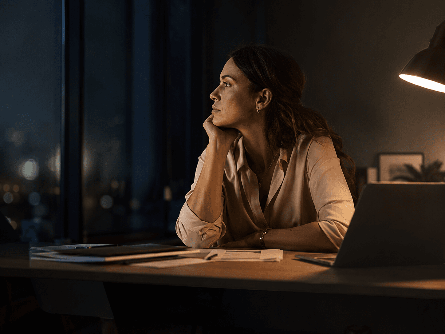 Réflexion nocturne dans un bureau, portée par une fatigue lucide.
